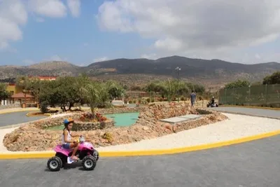 Kız bir tatil parkında dörtlü bisiklete biniyor.